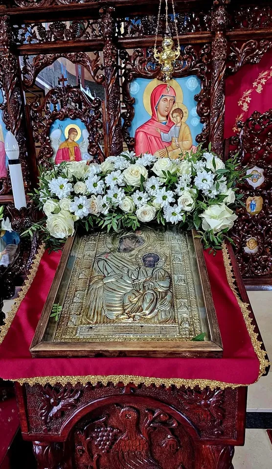Icoană pe masa de închinare, împodobită cu flori